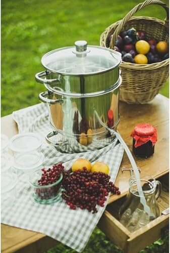 Cuiseur vapeur en métal avec fruits sur une table.